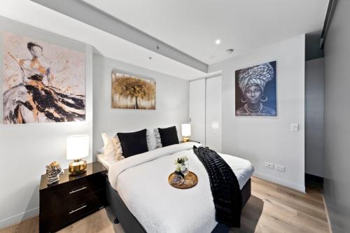 sypialnia z łóżkiem i dwoma obrazami na ścianie w obiekcie Amazing & Cozy Apt Right Next to Southern Cross w Melbourne