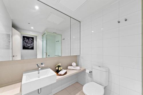 a bathroom with a toilet and a sink and a mirror at Amazing & Cozy Apt Right Next to Southern Cross in Melbourne