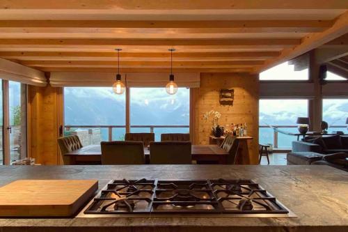 a kitchen and living room with a stove top oven at Chalet VG stunning view, Sauna & Jacuzzi by Jolidi in Nendaz