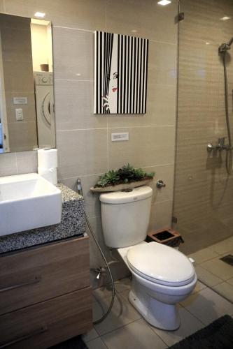 a bathroom with a toilet and a sink and a shower at McKinley Hills BGC Taguig City Condo in Manila