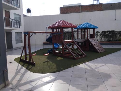 a playground with two swings and a slide at Céntrico y estiloso apartamento con Alberca, AC, Seguridad, Aparcamiento y Gym in Guadalajara