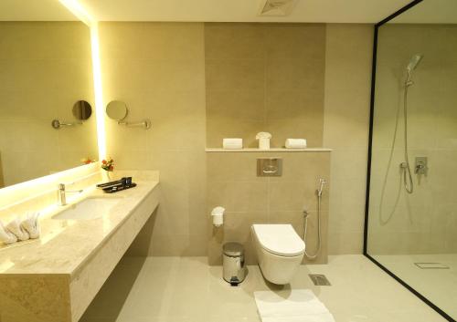 a bathroom with a toilet and a sink and a shower at Farhan Tower in Juffair