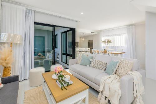 a living room with a couch and a table at East Vic Park Luxe New Home in Perth