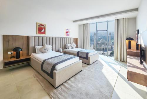 a hotel room with two beds and a large window at Farhan Tower in Juffair