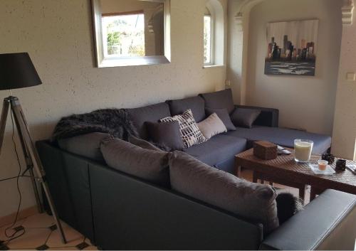 uma sala de estar com um sofá azul e uma mesa em Grande maison à louer à La Londe les maures em La Londe-les-Maures