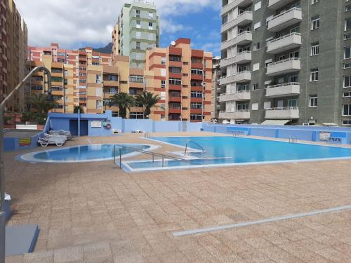een zwembad in een stad met hoge gebouwen bij Apartbeach Marina in Candelaria