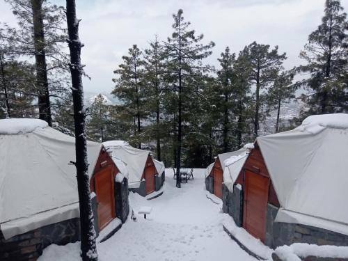 a row of tents covered in snow at Orange Loft, Glamp Park Murree in Murree
