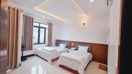 een slaapkamer met 2 bedden en een raam bij An vũ hotel in Bak Kan