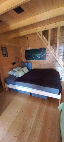 Bett in einem Zimmer mit Holzdecke in der Unterkunft KORCAL faházak in Koroncó