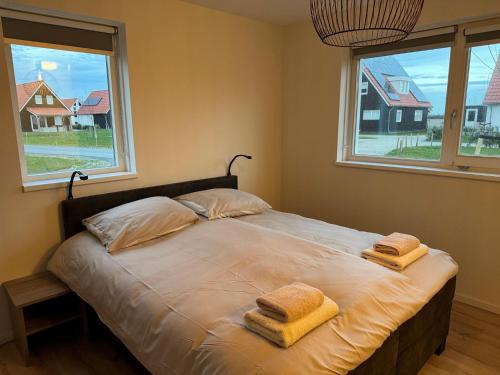1 dormitorio con 1 cama con 2 toallas en Modern holiday home in Scherpenisse with infrared sauna, en Scherpenisse