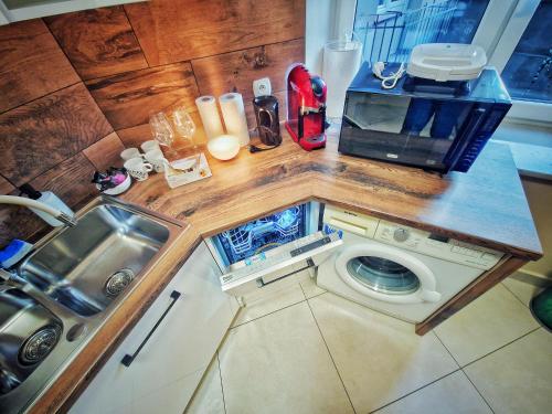 a small kitchen with a microwave and a washing machine at Summer Apartment in Przemyśl