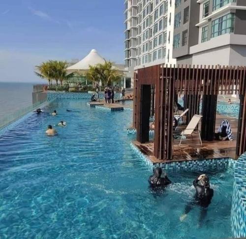 a group of people in the swimming pool at a hotel at Leisure Imperium Residence Studio Seaview Kuantan in Kuantan