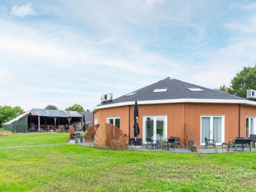 a house with a black roof on a grass field at Attractive holiday home in Gorp and Roovert estate in Goirle