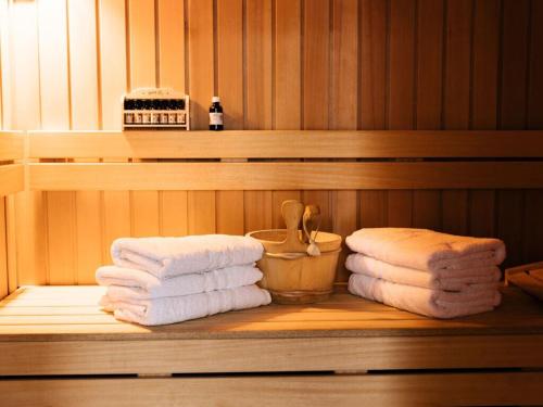einen Stapel Handtücher auf einem Regal in einer Sauna in der Unterkunft Holiday home Satijnduiker in Makkum