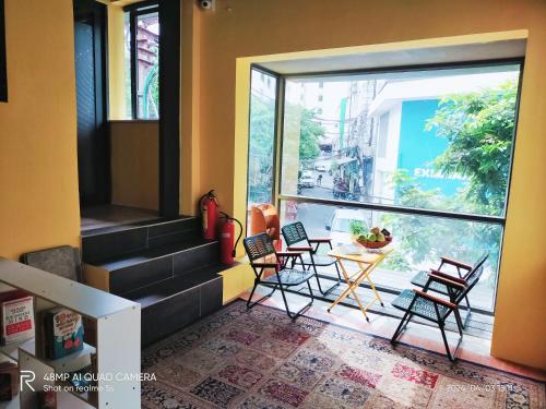 a room with chairs and a table and a large window at Shusimi Boutique Villa SG Near Tan Son Nhat Airport in Ho Chi Minh City