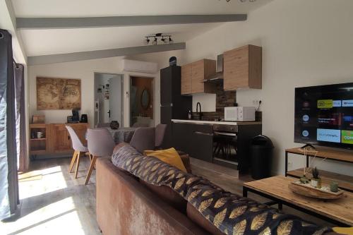 un salon avec un canapé et une table et une cuisine dans l'établissement Le Petit Clos des Chênes - 100% privatif, à Villeneuve-lès-Avignon