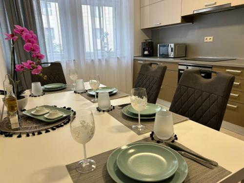 a dining room table with plates and wine glasses at LEO Apartment FREE PARKING - President Palace in Bratislava
