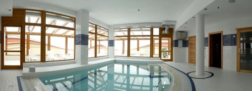 a large swimming pool in a building with windows at Rezidence & Wellness Blatov in Prague