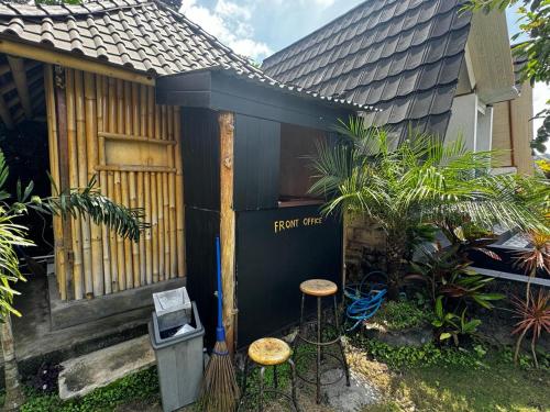 a small house with two stools in front of it at Belvilla Break Coffee Kintamani in Kintamani
