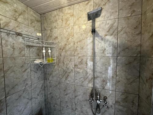 a bathroom with a shower with a shower head at Belvilla 93878 Private Room In Kintamani Near Toya Devasya in Kintamani