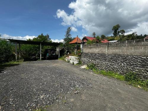 a dirt road next to a stone wall at Belvilla Break Coffee Kintamani in Kintamani