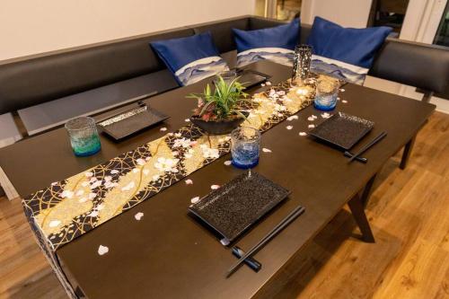 a table with plates and utensils on top at 駐車場にコインランドリー畳部屋にお布団も敷けます最上階4階Room in Tomari