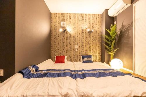 a bedroom with a large bed with red and blue pillows at 駐車場にコインランドリー畳部屋にお布団も敷けます最上階4階Room in Tomari