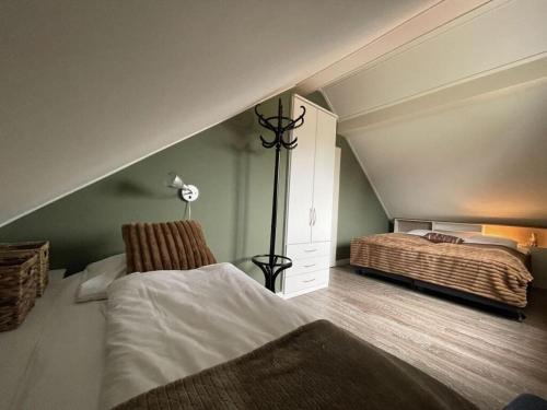 um quarto no sótão com uma cama e um candeeiro em Holiday apartment Rietzanger for 10 peop em Makkum