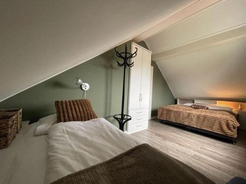 a attic bedroom with a bed and a lamp at Holiday apartment Rietzanger for 10 peop in Makkum