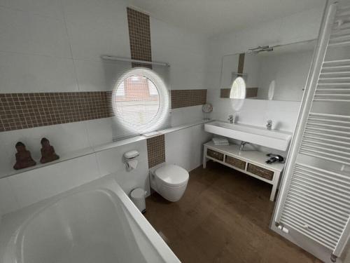 uma casa de banho com uma banheira, um WC e um lavatório. em Holiday apartment Rietzanger for 10 peop em Makkum