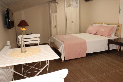 a small room with two beds and a table at Ede Apart Otel in Geyikli