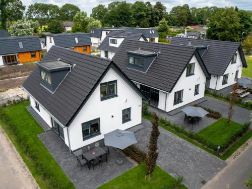 una vista aérea de una casa con techo en Beautiful holiday home with lots of space in a holiday park near Alkmaar, en Hensbroek