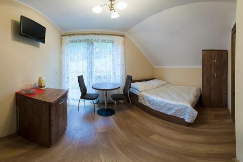 a bedroom with a bed and a table and chairs at Willa Solina144 in Solina