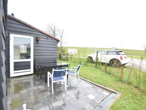 a patio with a table and chairs and a car at Holiday Home Nieuwvliet-Bad near Beach in Nieuwvliet-Bad