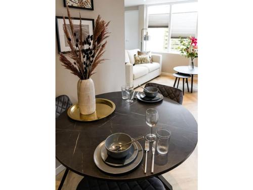 a dining room table with plates and glasses on it at Holiday apartment Costa in Callantsoog