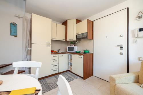 une petite cuisine avec des armoires blanches et une table dans l'établissement Isa Petit Bijou - Happy Rentals, à Menton