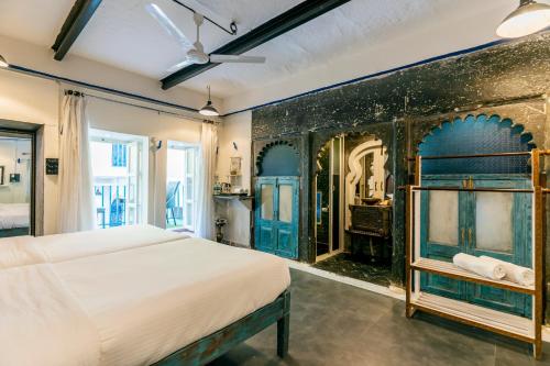 a bedroom with a bed and a wall with blue at Barefoot Boutique Hotel Udaipur in Udaipur