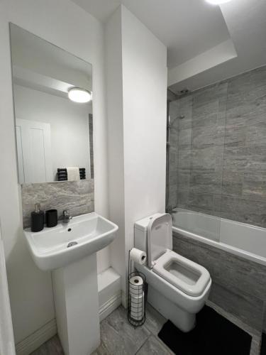 a bathroom with a sink and a toilet and a tub at Tranquil 1BR in Catford in London