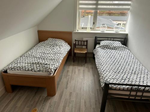 2 camas en una habitación pequeña con ventana en Modern spacious holiday home with lovely backyard and veranda in Limmen en Limmen