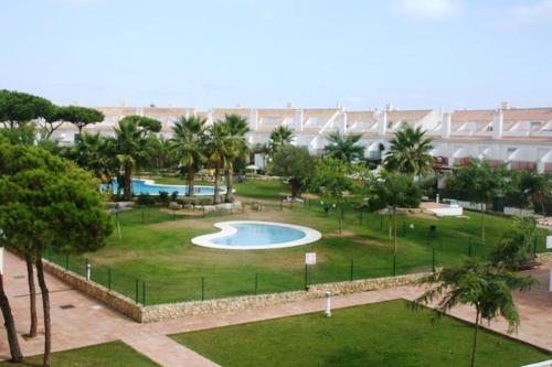 uitzicht op een park met 2 zwembaden bij Adosado en Hoyo 14, junto al campo de golf Nuevo Portil NP14442 in El Portil