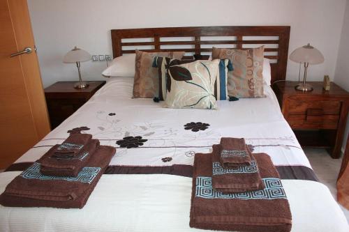 een slaapkamer met een bed met handdoeken erop bij Adosado en Hoyo 14, junto al campo de golf Nuevo Portil NP14442 in El Portil