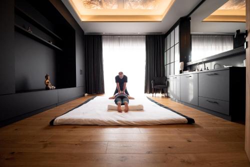 a person is sitting on a bed in a kitchen at Avita Resort Bad Tatzmannsdorf in Bad Tatzmannsdorf