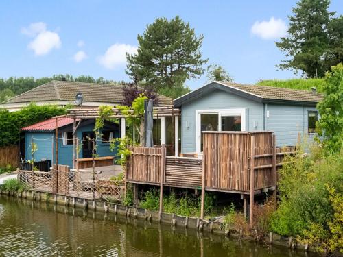 een blauw huis aan de kant van een rivier bij Idyllic Holiday Home in Ooltgensplaat near centre in Ooltgensplaat