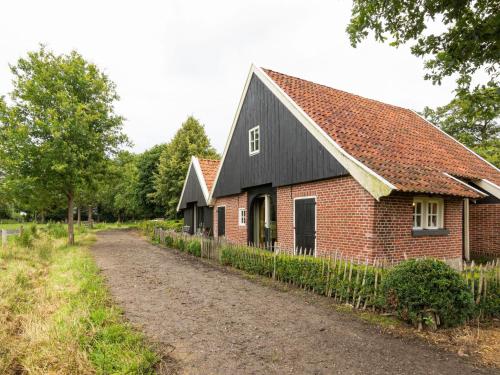 エンスヘーデにあるCozy Apartment in Enschede near Forestの未舗装の黒屋根のレンガ造り