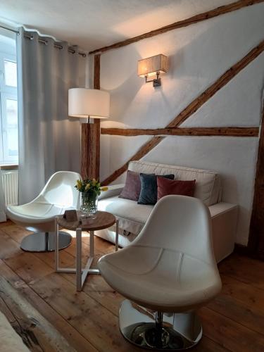 a living room with two white chairs and a couch at Zajazd Karczma Zagłoba in Świdnica