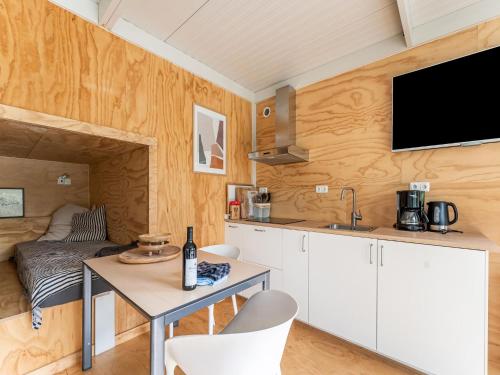 uma cozinha com uma mesa e uma televisão na parede em Comfortable holiday home in Den Ham with garden em Den Ham