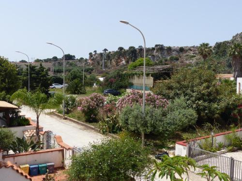 uma vista para uma rua com árvores e arbustos em Villetta Fiorita em San Vito lo Capo