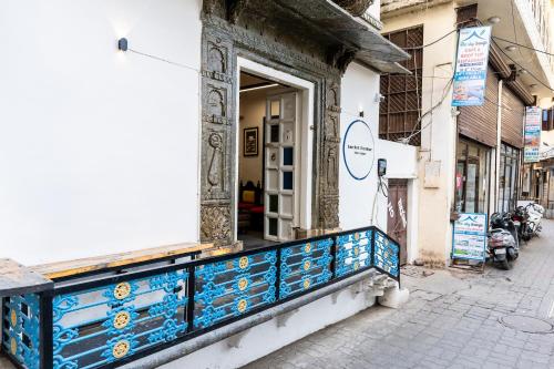 a building with a blue and white railing on a street at Barefoot Boutique Hotel Udaipur in Udaipur