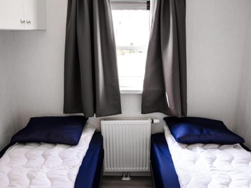2 camas en una habitación con ventana en Modern chalet with two terraces and near a pond, en De Bult