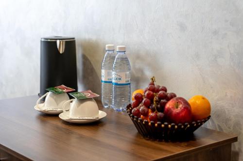 a bowl of fruit and bottles of water on a table at MILDOM Express in Almaty